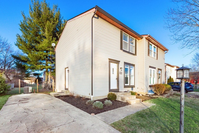 view of front facade with a front yard and central AC unit