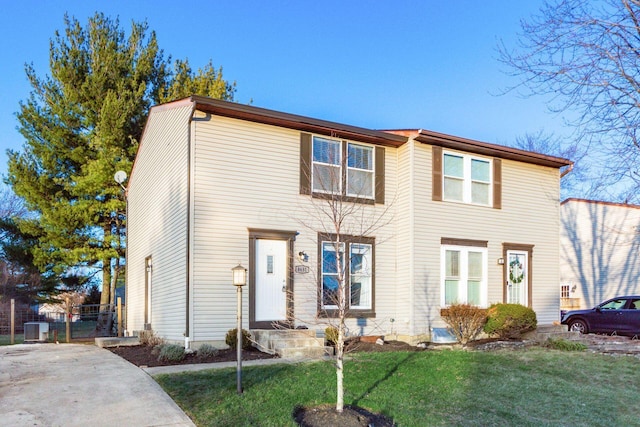 view of front of home with a front yard and central AC unit