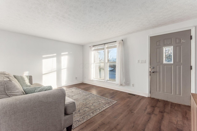 entrance foyer with dark hardwood / wood-style flooring and a textured ceiling