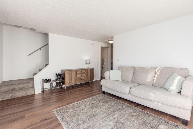 living room featuring dark hardwood / wood-style flooring and a textured ceiling