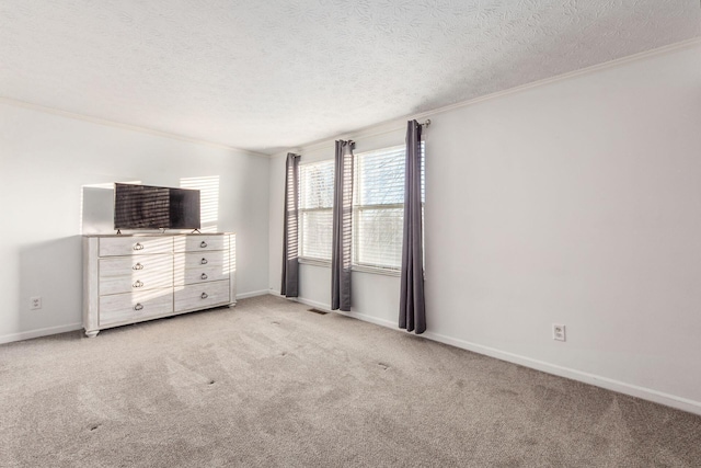 unfurnished bedroom featuring a textured ceiling, light colored carpet, and ornamental molding