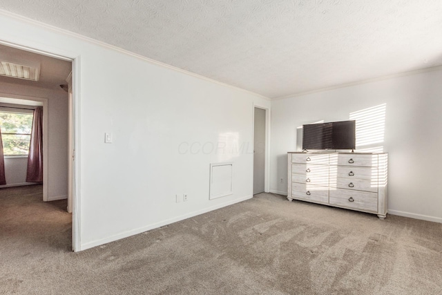 unfurnished bedroom featuring light colored carpet, a textured ceiling, and multiple windows