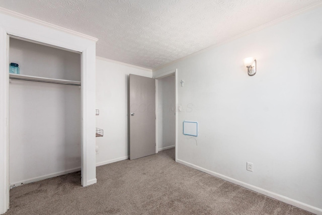 unfurnished bedroom featuring a textured ceiling, carpet floors, a closet, and crown molding