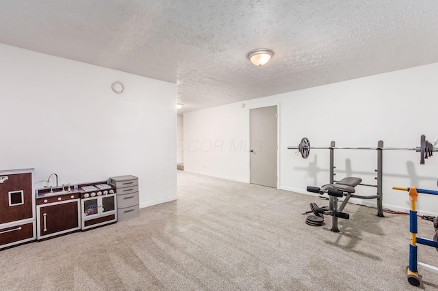 exercise room featuring carpet and a textured ceiling