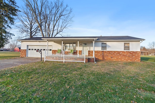 ranch-style house with covered porch, a garage, and a front yard