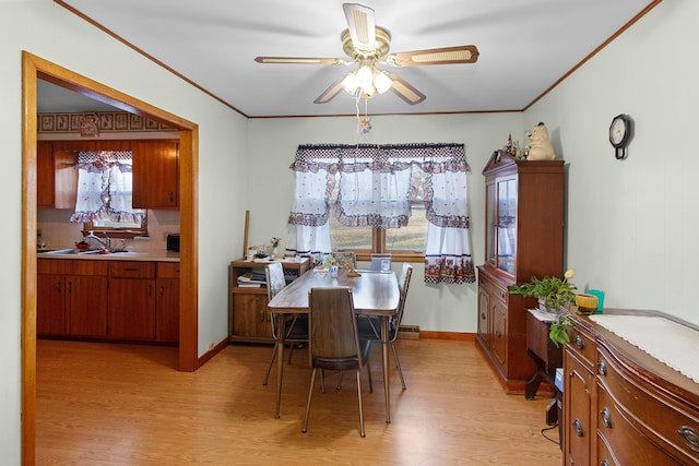 dining room featuring ceiling fan, sink, light hardwood / wood-style floors, and ornamental molding