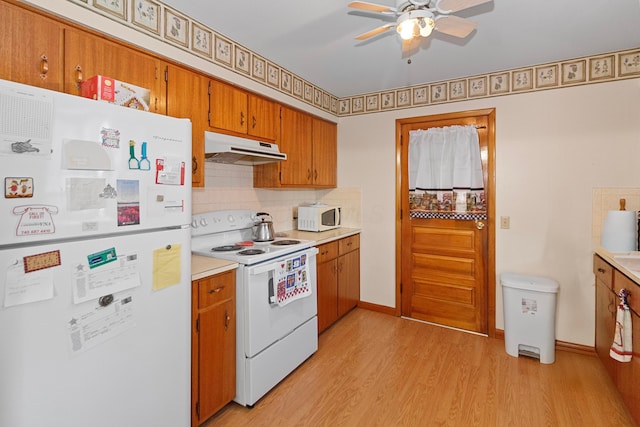 kitchen with ceiling fan, light wood-type flooring, white appliances, and backsplash