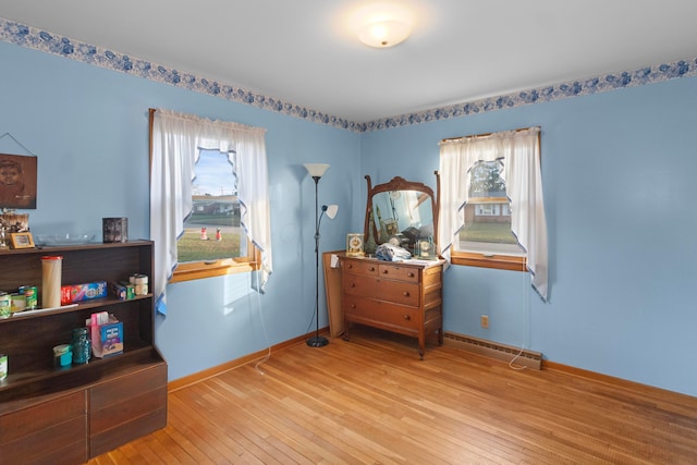 misc room with hardwood / wood-style floors and a baseboard heating unit