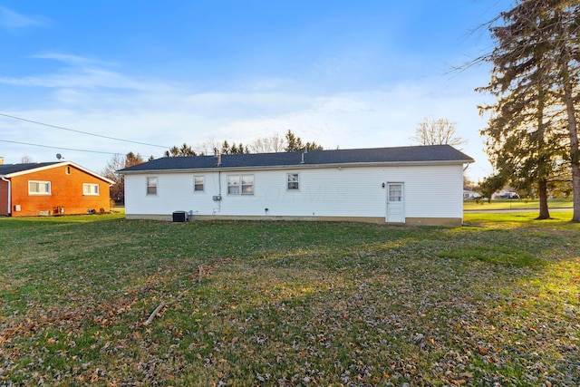 back of house featuring a lawn and central AC unit