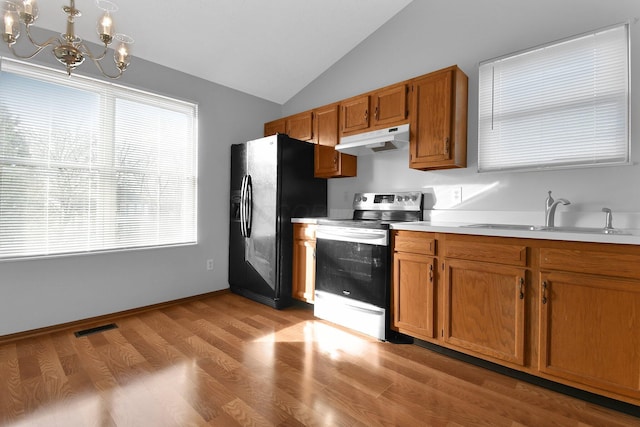 kitchen with sink, an inviting chandelier, black fridge, vaulted ceiling, and electric stove