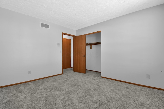 unfurnished bedroom with light carpet, a closet, and a textured ceiling