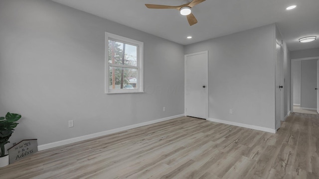 empty room with ceiling fan and light hardwood / wood-style floors