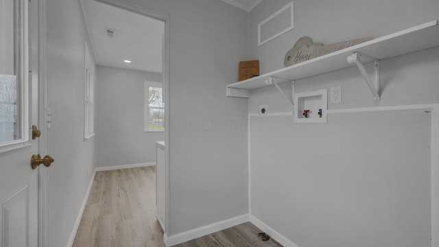 washroom with electric dryer hookup, light hardwood / wood-style floors, ornamental molding, and hookup for a washing machine