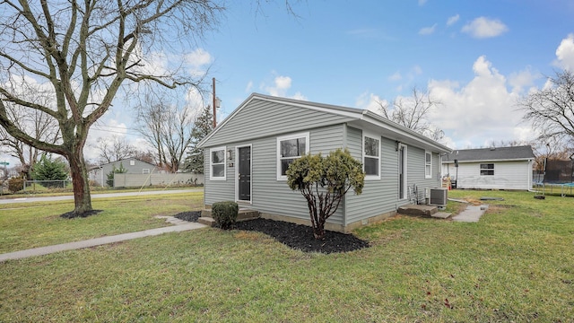 view of property exterior featuring a yard, a trampoline, and central air condition unit