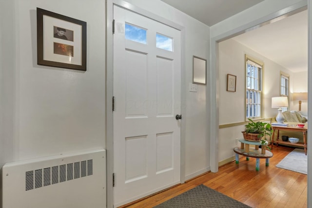 entrance foyer featuring radiator heating unit and wood-type flooring