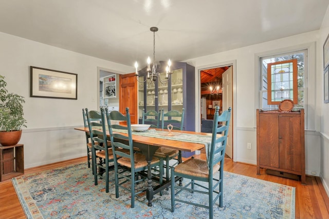 dining area featuring light hardwood / wood-style flooring and an inviting chandelier