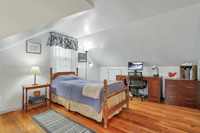 bedroom featuring light hardwood / wood-style flooring and lofted ceiling