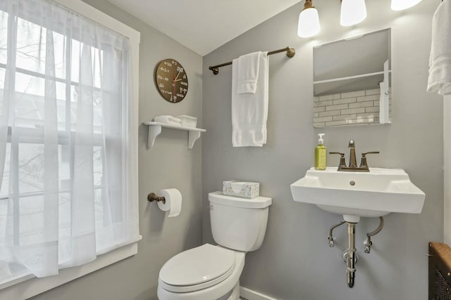 bathroom with sink, vaulted ceiling, and toilet