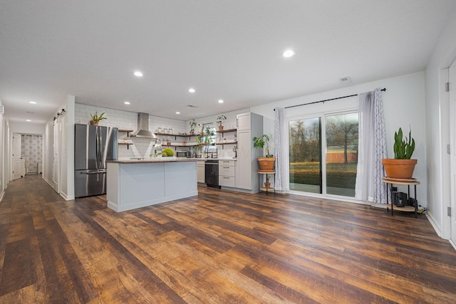 kitchen with a center island, wall chimney exhaust hood, dark hardwood / wood-style flooring, white cabinetry, and stainless steel refrigerator