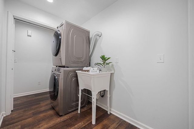 washroom with stacked washing maching and dryer and dark wood-type flooring