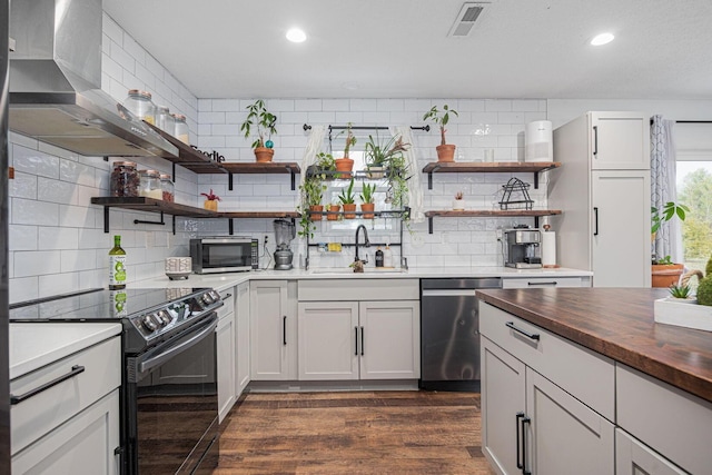 kitchen featuring backsplash, stainless steel appliances, dark wood-type flooring, sink, and white cabinets