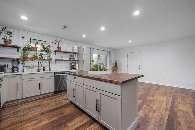 kitchen featuring dark hardwood / wood-style floors, sink, wooden counters, and stainless steel dishwasher