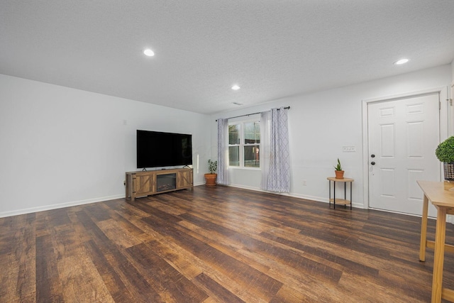 unfurnished living room with dark hardwood / wood-style floors and a textured ceiling