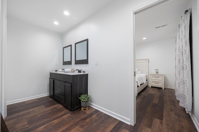 bathroom with hardwood / wood-style floors, vanity, and a textured ceiling