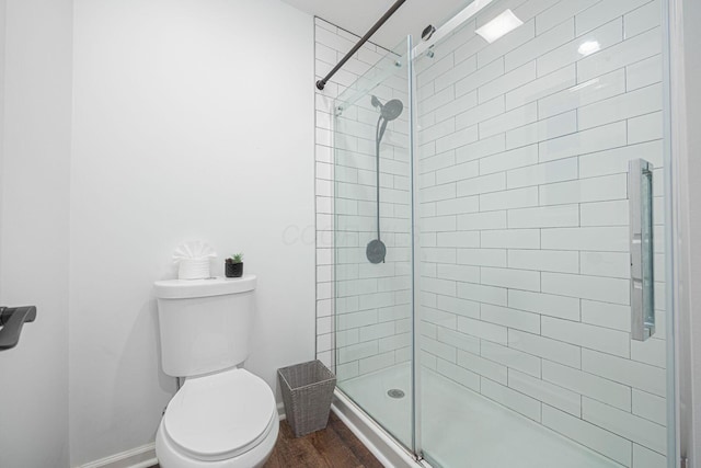 bathroom with an enclosed shower, toilet, and hardwood / wood-style floors