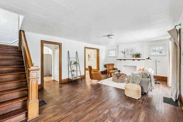 living room with a tile fireplace and hardwood / wood-style floors