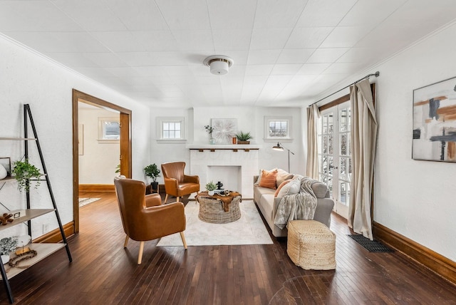 living room with a brick fireplace and dark wood-type flooring