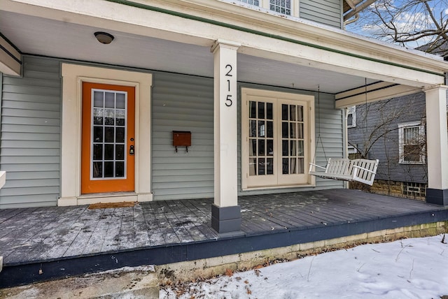 snow covered property entrance with french doors