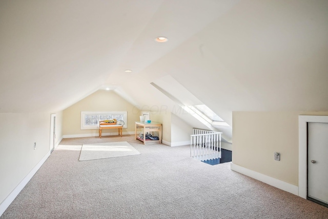 bonus room featuring vaulted ceiling with skylight and light carpet