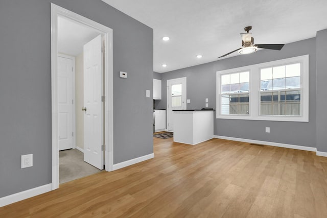 unfurnished living room with ceiling fan and light hardwood / wood-style flooring