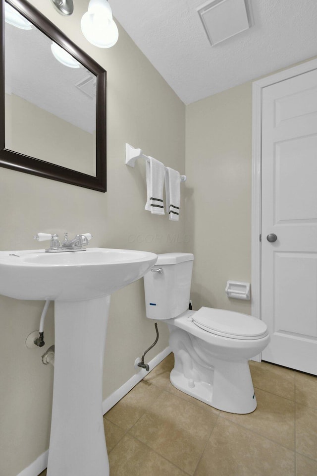 bathroom with toilet and tile patterned flooring