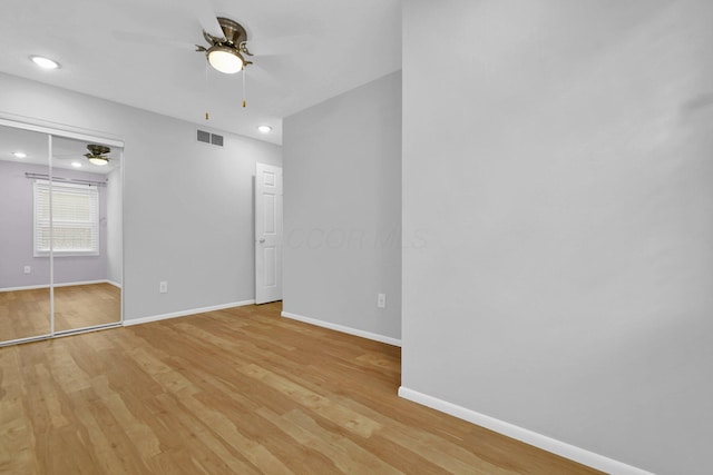 unfurnished bedroom with ceiling fan, light hardwood / wood-style floors, and a closet