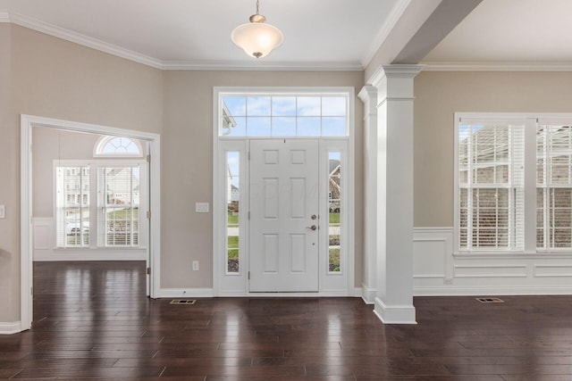 foyer with decorative columns, crown molding, a healthy amount of sunlight, and dark hardwood / wood-style floors