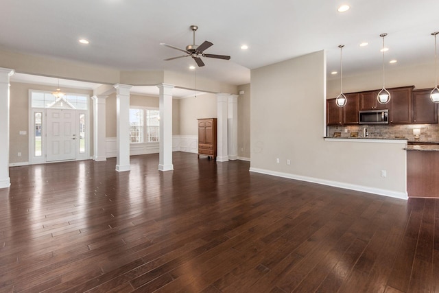 unfurnished living room with ceiling fan and dark wood-type flooring