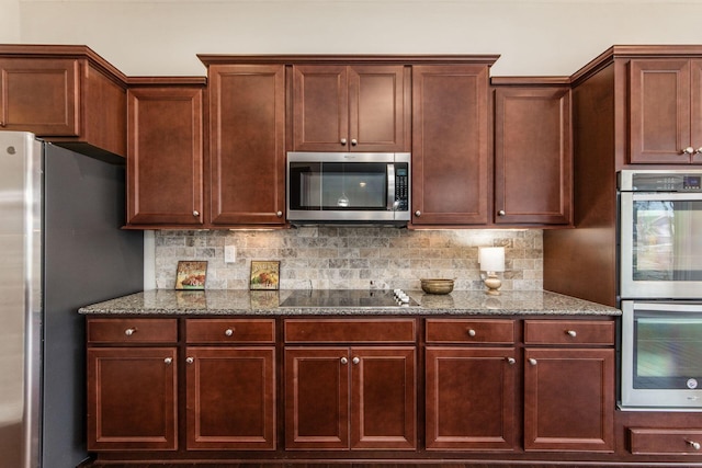 kitchen with dark stone countertops, decorative backsplash, and appliances with stainless steel finishes