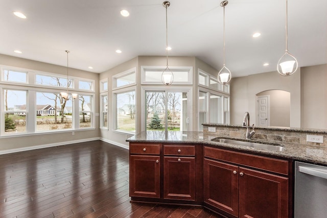 kitchen featuring pendant lighting, dishwasher, sink, dark hardwood / wood-style floors, and light stone counters