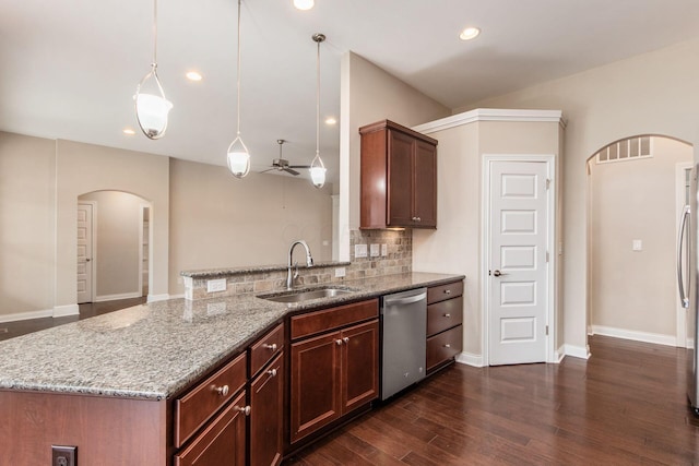 kitchen with light stone counters, stainless steel appliances, ceiling fan, sink, and hanging light fixtures