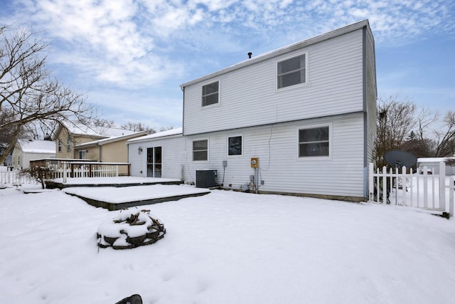 snow covered rear of property with central AC