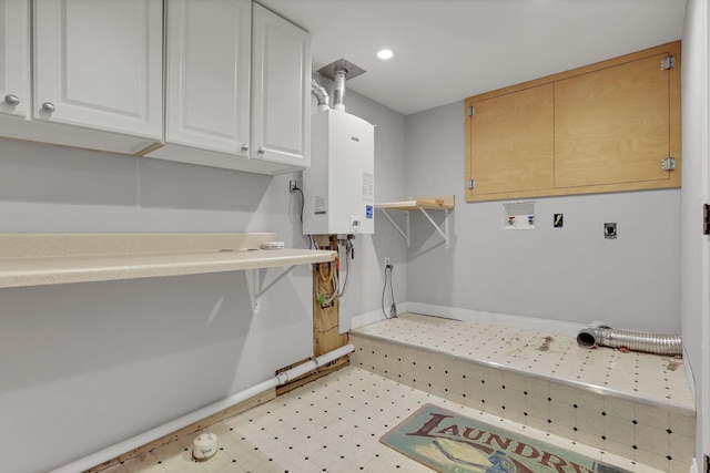 washroom with washer hookup, cabinets, water heater, and hookup for an electric dryer