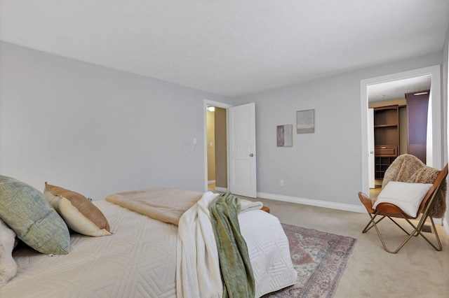 carpeted bedroom featuring a walk in closet and a closet