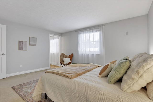 bedroom with light colored carpet and a textured ceiling