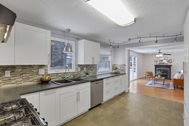 kitchen featuring white cabinets, pendant lighting, decorative backsplash, sink, and stainless steel dishwasher