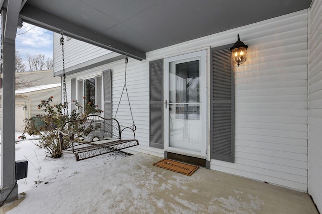 snow covered property entrance featuring covered porch