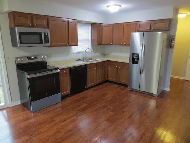 kitchen featuring appliances with stainless steel finishes, dark wood-type flooring, and sink