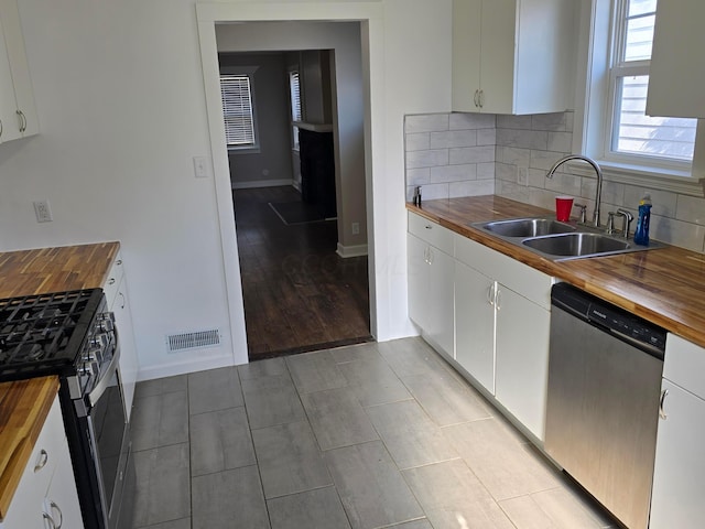 kitchen featuring white cabinets, appliances with stainless steel finishes, and wooden counters