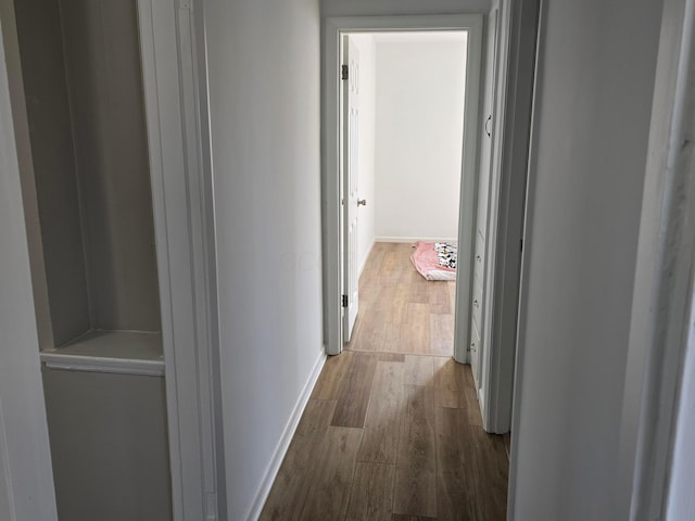 corridor with hardwood / wood-style flooring